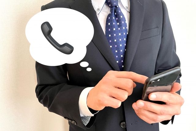 問い合わせの電話をする男性の画像